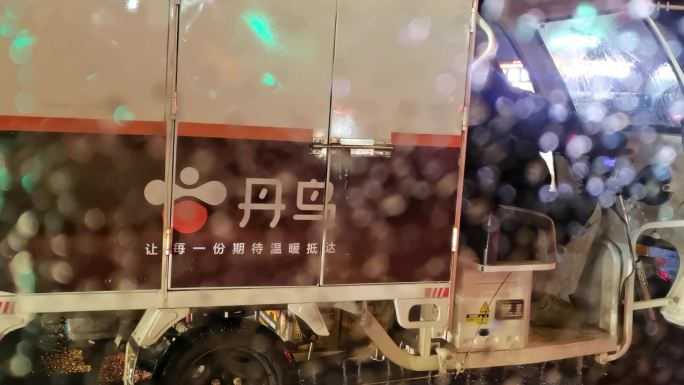 雨中快递车，十字路口雨中的丹鸟快递车