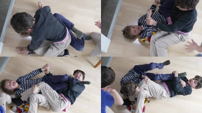 兄弟之间的战斗，兄弟姐妹在地板上摔跤和争吵。兄弟之间的竞争，兄弟在地板上摔跤激烈的争吵