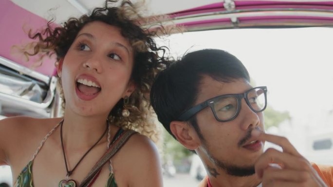 年轻的亚洲夫妇在城市街道上欣赏风景并交谈。