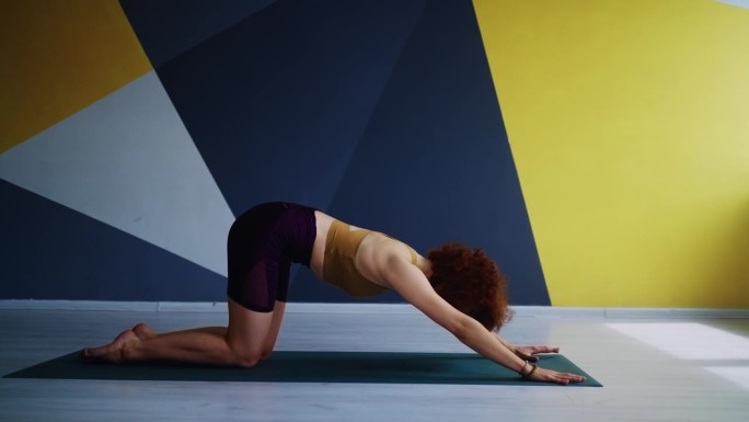 女运动员示范困难的体式和运动，瑜伽练习在健身工作室早上