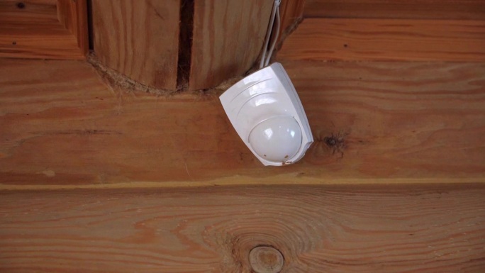 一个木头房子里的火灾报警传感器，闪烁着红灯