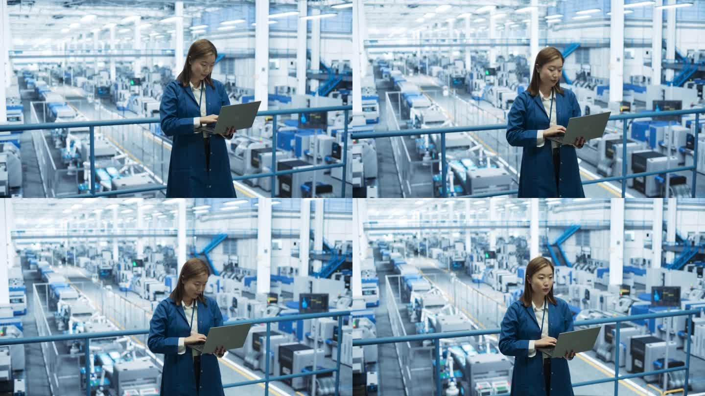 电子制造技术人员在工厂空间里操作笔记本电脑。亚洲女性专家为机器生产和装配开发，维护，微调程序