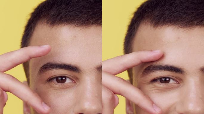在摄影棚里拍摄的一个人的脸、眼睛和手指，背景是黄色的。肖像、微笑或表情符号，以及一个快乐的年轻人或模