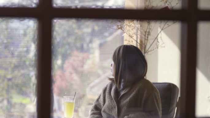 女孩晒着阳光看书喝下午茶