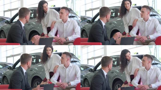 一对年轻夫妇在汽车商店和销售顾问谈话，他正在给他们介绍一辆汽车
