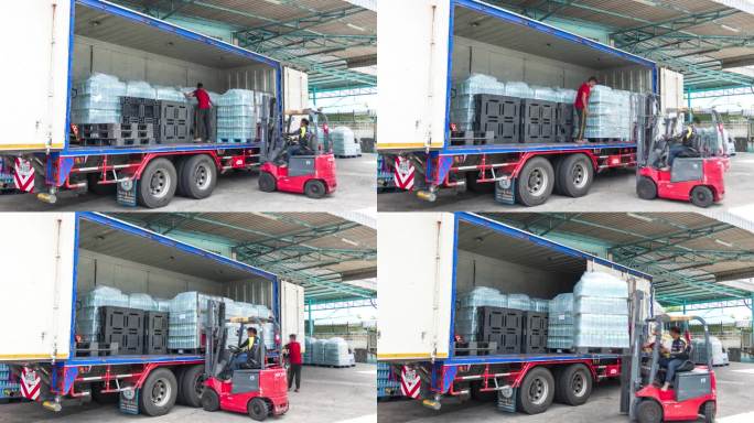 产品运输:大型集装箱卡车准备将大量瓶装水运送给客户。
