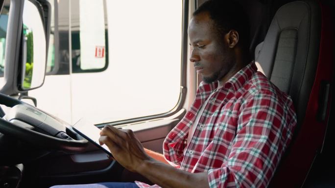 专业非洲卡车司机使用卡车gps导航运输和交付货物到目的地。右舵车