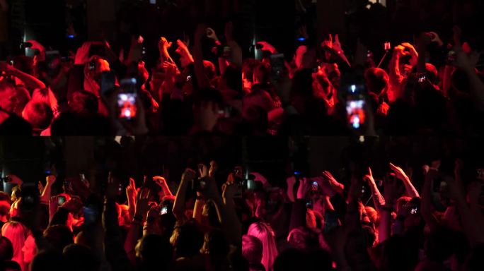免费音乐会，人群，歌迷，欢快地跳舞，举手，在闪光灯下拍摄手机视频