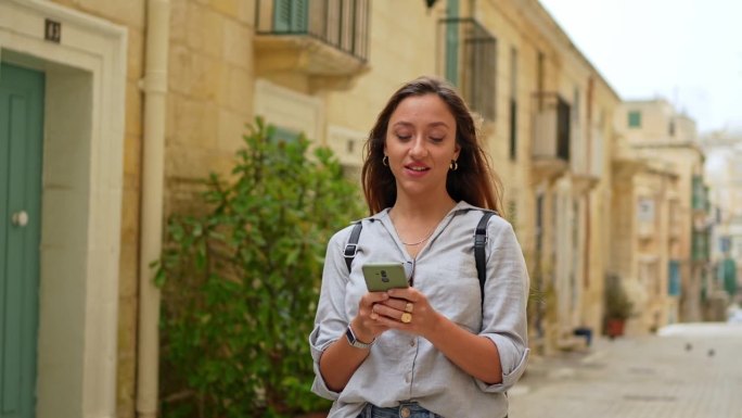年轻的女游客在瓦莱塔用智能手机查找路线