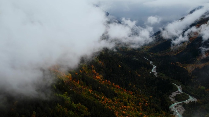 美丽的空中全景高山和山谷在多云的天气，相机飞越云层