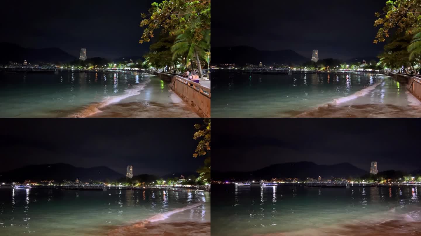 夜晚的泰国普吉岛芭东海滩，美丽的白色沙滩和蓝绿色的海水上灯火通明。远处的闪电和烟花