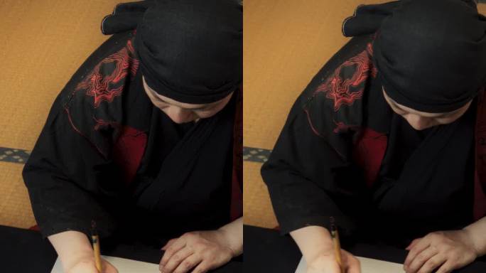 竖屏:日本艺术家为客户创作委托书法作品。成人书法家坐在传统的工作室里，用墨水在纸上书写汉字符号