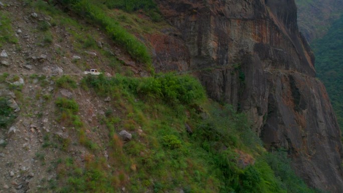 鸟瞰白色车辆与游客驾驶上坡在风景秀丽的山区砾石路。玛南之路。探险旅游，自驾游，喜马拉雅山脉度假旅游。