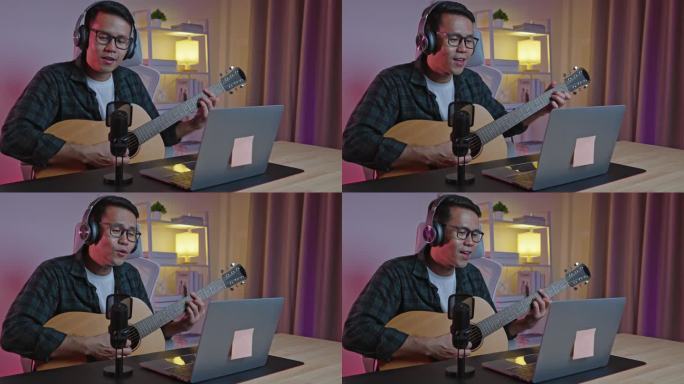 亚洲男子youtube直播表演弹吉他和唱一首歌。亚洲人在网上教吉他和唱歌。音乐家用笔记本电脑录制音乐