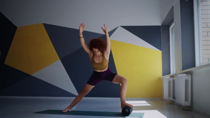 熟练的瑜伽女性在工作室做运动和体式，一名女性在健身中心训练