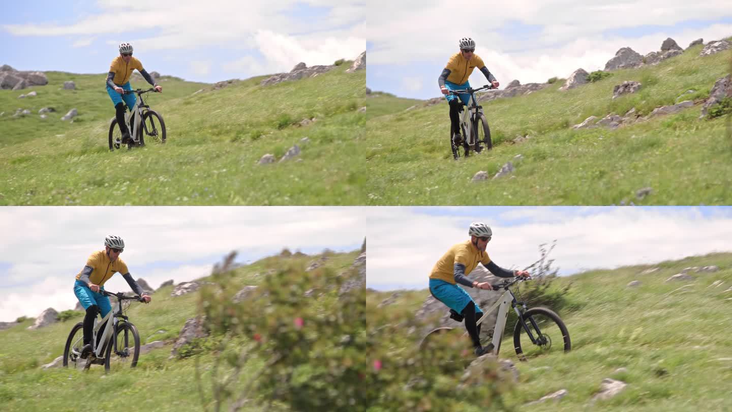 一名男子在阳光下的山上骑着他的电动自行车