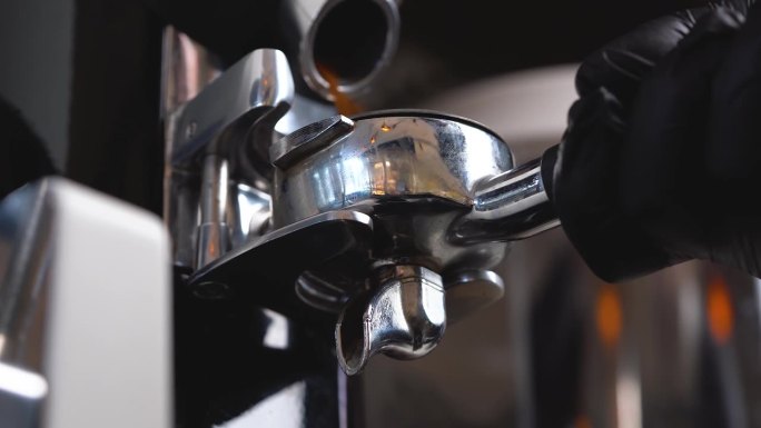 咖啡师将咖啡豆研磨机里的咖啡粉放入咖啡过滤机