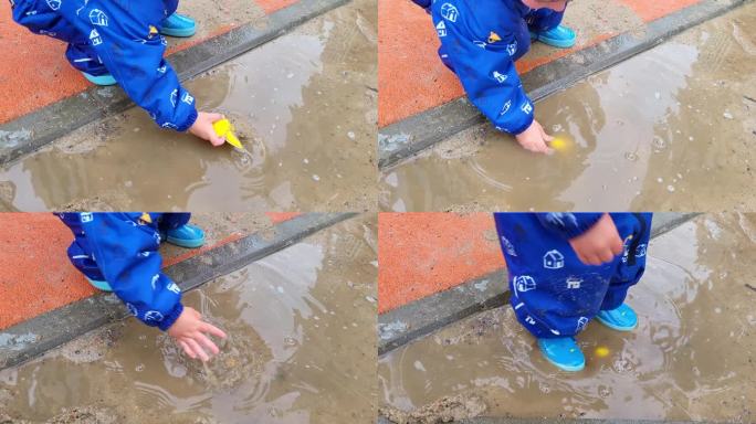 孩子在水坑里玩他的玩具玩得很开心，很享受手上的水和泥的感觉