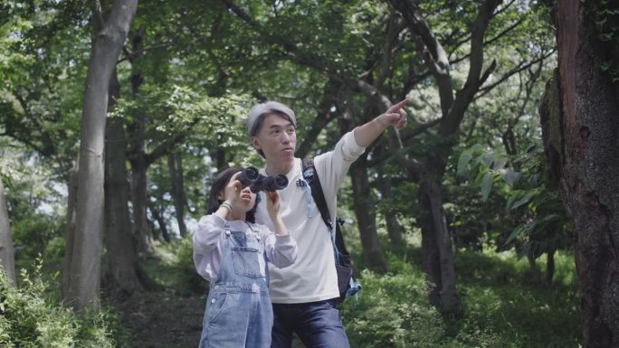 日本父亲在教女儿如何使用双筒望远镜
