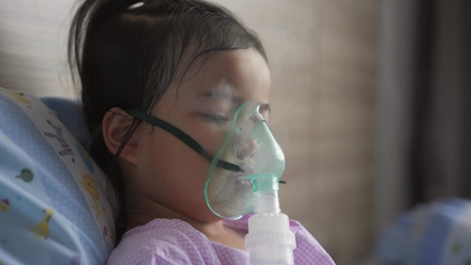 一个勇敢的亚洲小女孩正在用口罩呼吸