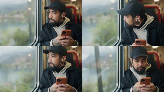 一名亚洲游客在火车上通勤，一边看手机，一边欣赏风景。