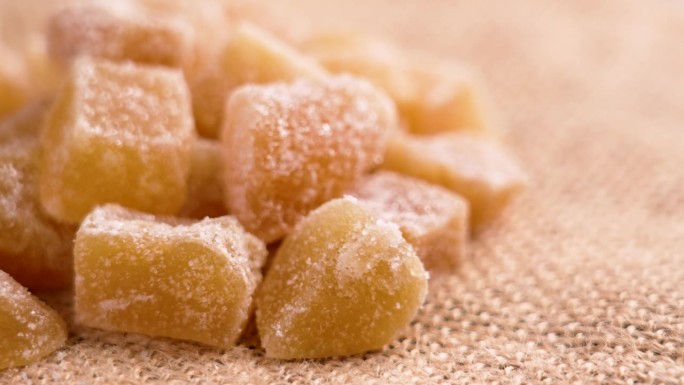 结晶的姜糖靠近粗糙的粗麻布。甜的健康食品