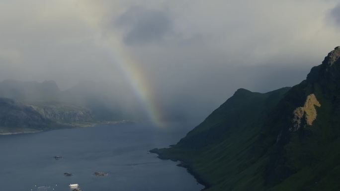 美丽的彩色彩虹在斯堪的纳维亚峡湾的水面上。无人机的观点
