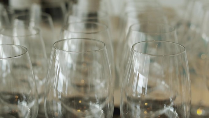 在一个优雅的餐厅，这显示了一排排的空水晶透明酒杯，豪华和精致的美丽象征，玻璃器皿等待着塑造一个难忘的