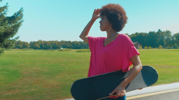 快乐、酷、漂亮的非裔美国女人在公园里滑滑板