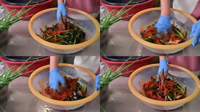 制作传统韩国菜泡菜的过程。一位戴着手套的妇女正在准备制作泡菜所需的各种材料。