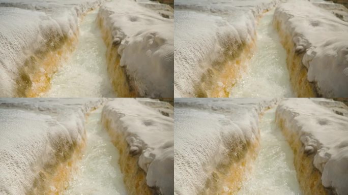 方解石钟乳石，一种白色的石质通道，形似峡谷，纯水从泉中流过，Pamukkale。慢动作。