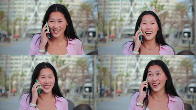 慢动作镜头，一个亚洲女人一边走一边用智能手机友好地交谈。中国漂亮的女学生微笑着用手机聊天。女孩用手机