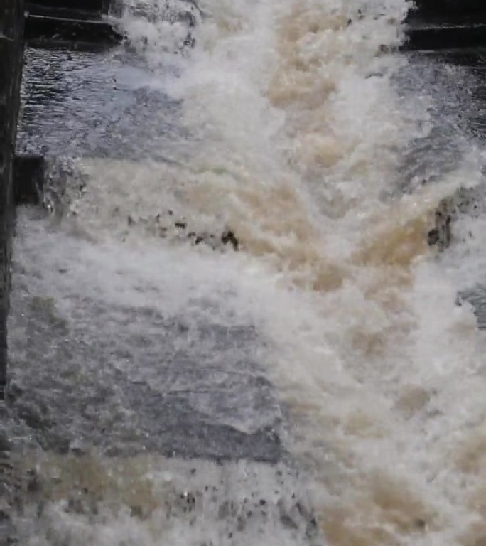 雨水汹涌地冲过这条人工河道，其力量被巨大的水量放大了。