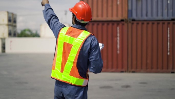 物流人员检查数据，调查和检查运输公司区域的堆垛集装箱。