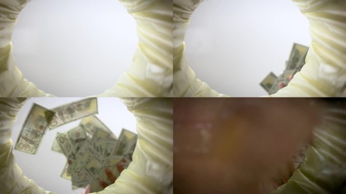 美钞落入废纸篓的超级慢动作镜头。