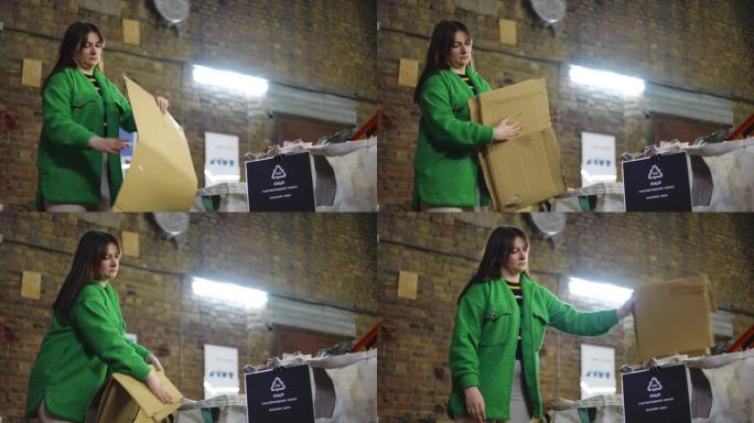 严肃的女人折叠纸垃圾，把垃圾放在盒子里，上面写着“纸混合”字样。白人妇女在垃圾回收站整理垃圾的肖像。
