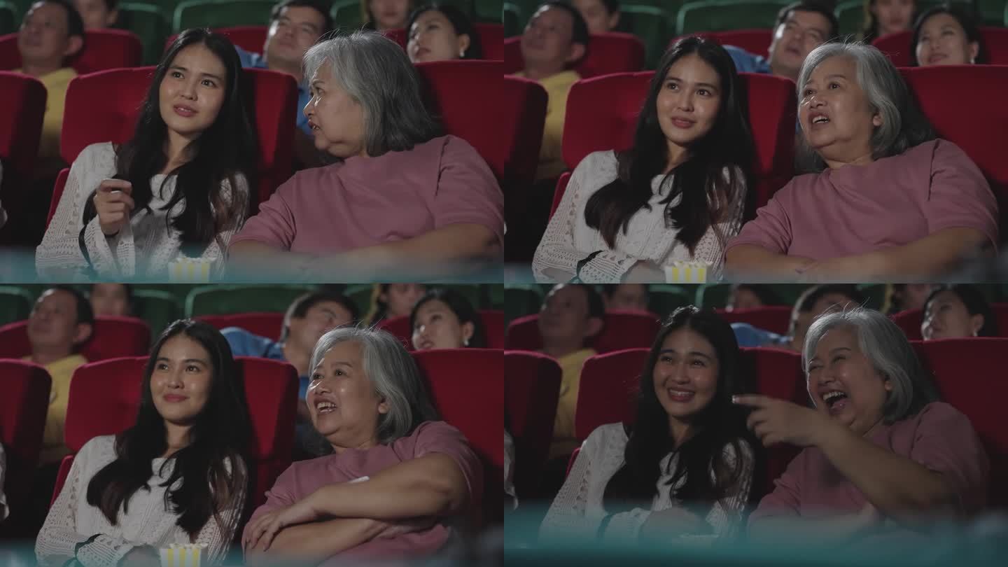 亚洲老年母女在电影院欣赏电影。在电影院看喜剧电影的快乐母女。娱乐和享受概念