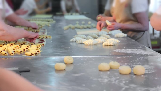 几个女工在面包店里准备草莓夹心饼干和百吉饼。各种各样的饼干是由妇女用手从面团中制作出来的。近距离
