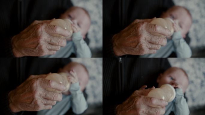 正上方的特写镜头，爷爷在家里用手从奶瓶里给小男孩喂牛奶
