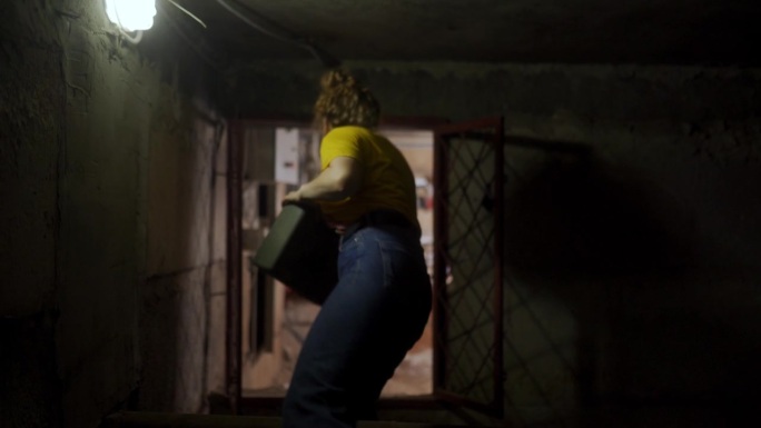 下面是女水管工在黑暗地下室朝锅炉房走去的背影。女工程师拿着工具箱走过地下一层