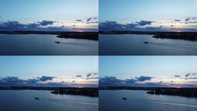芬兰，深蓝色的赫尔辛基，夕阳西下，渔船在海上行驶