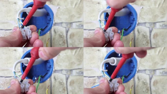 拆卸壁插座，维修人员拧下端子座上固定电线的螺丝。