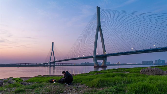 男子在武汉沌口长江大桥旁拍日转夜延时摄影