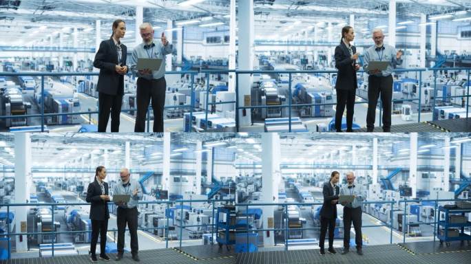 男工程师和女工程师站在工厂里，使用笔记本电脑，在工厂里与为不同行业生产现代电子元件的设备交谈