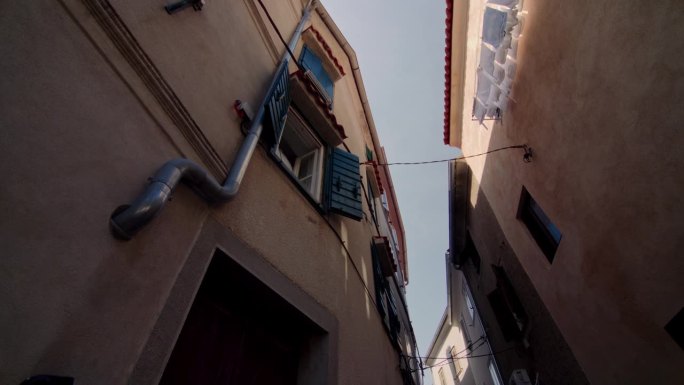 在欧洲，从建筑立面穿过阴凉小巷的开窗向上倾斜