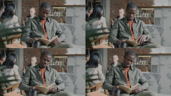 年轻的非裔美国男学生在咖啡馆里微笑着读书