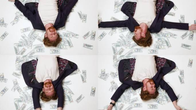 一个年轻的富有的企业家赢得了一个启动项目，躺在地板上。快乐的男商人。