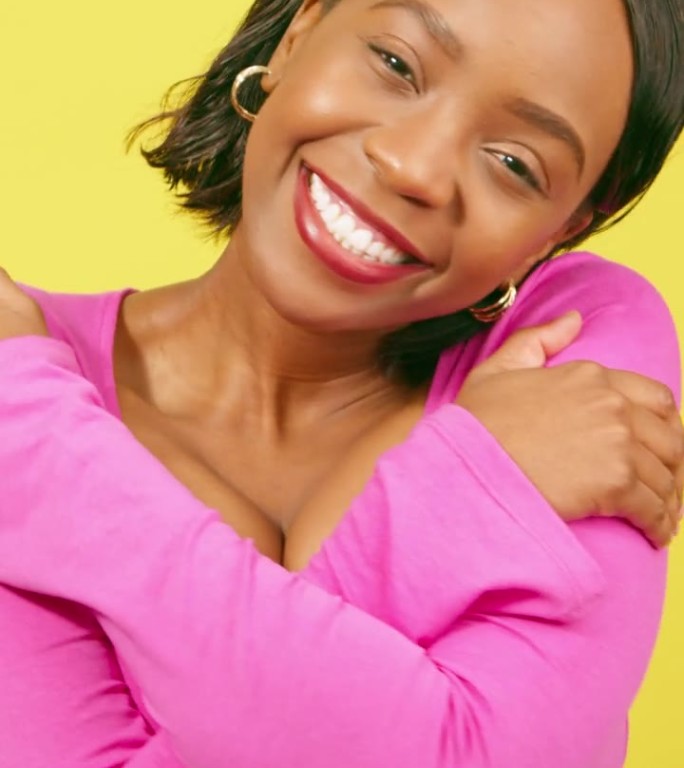 黑人妇女摩擦手臂，拥抱，自爱概念，黄色工作室背景