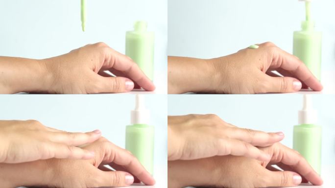 绿色保湿精华液滴在女人的手上，护肤化妆品。柔和绿色的精华液或凝胶从移液管滴在干燥的皮肤上。水疗中心的
