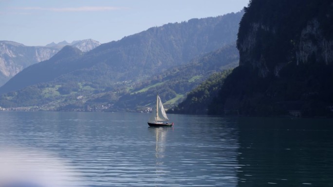 瓦伦湖上帆船的电影广角镜头，高山背景，慢镜头。瑞士Weesen